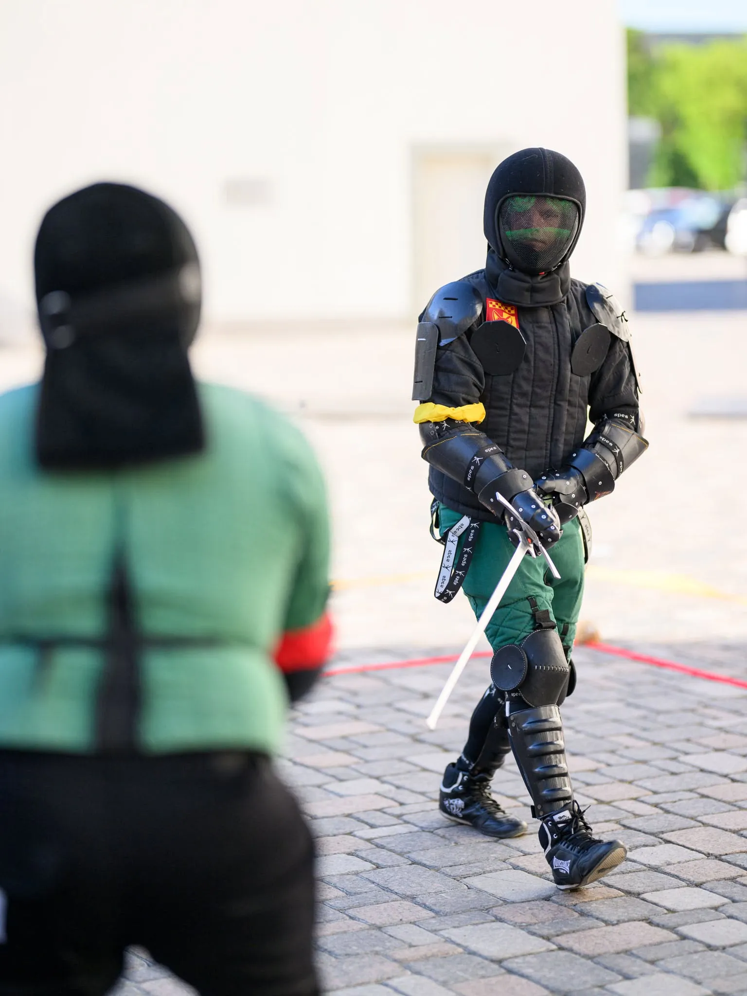 Fechtuotojas su pilna apsaugine įranga ir kalaviju ruošiasi kovai lauke